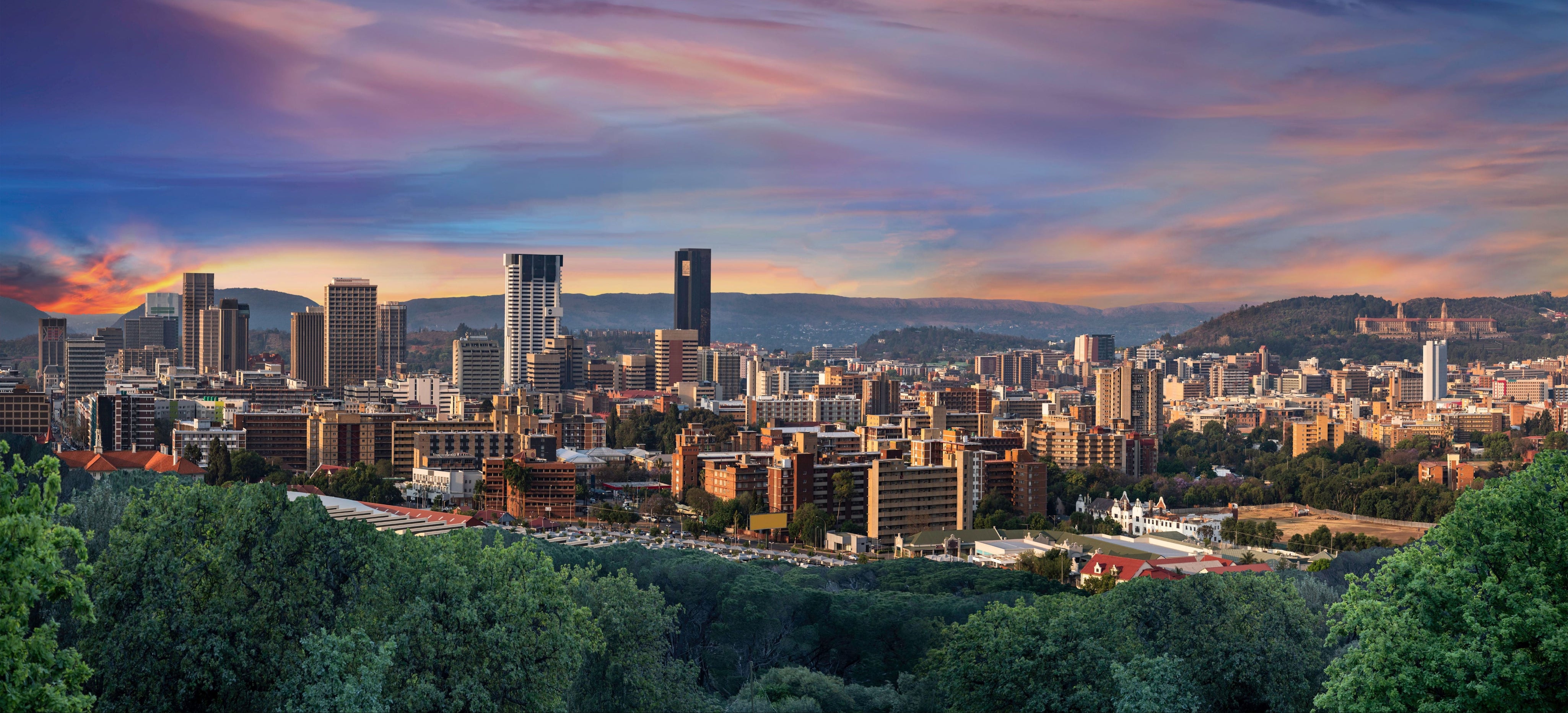 Cityscape of pretoria and a colorful sky at sunset.