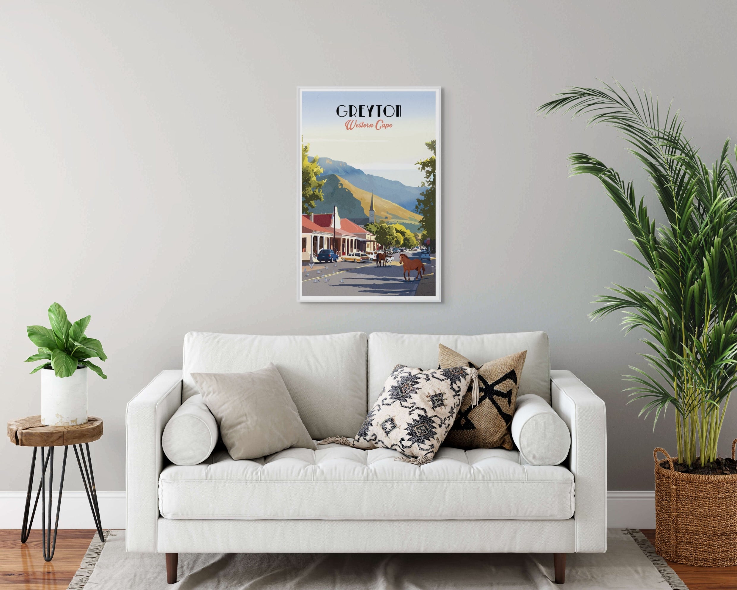 Living room with a white sofa, decorative pillows, and a framed Greyton artwork on the wall.
