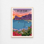 Hout Bay sunset poster with natural wood frame. Hout Bay sunset art print – illustrated coastal wall art featuring vibrant sunset over mountains and harbour, perfect for home decor.